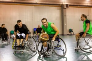Three disabled men play wheelchair basketball.